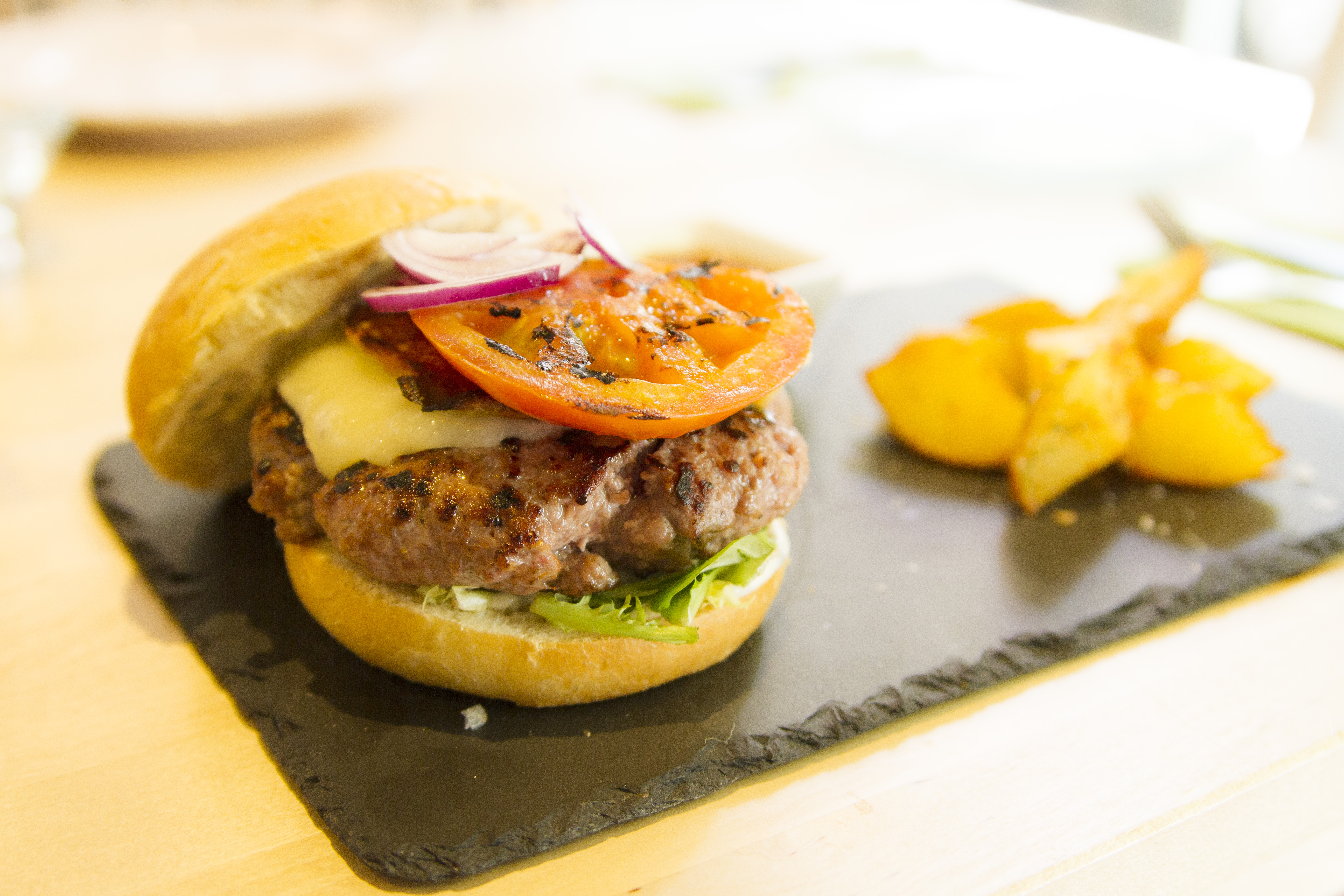 Hamburguesa de carne roja con tomate asado y provolone a la plancha con patatas gajo