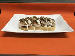 Tosta de solomillitos con cebolla caramelizada y salsa de pimienta