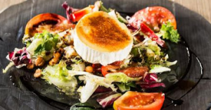 Ensalada con crujiente bacón, escamas queso cabra y vinagreta de frambuesa