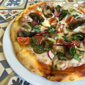 Tres “quesos” veganos, cebolla caramelizada, pesto de tomates secos y rúcula
