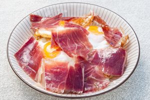 Huevos rotos con boletus y jamón de bodega