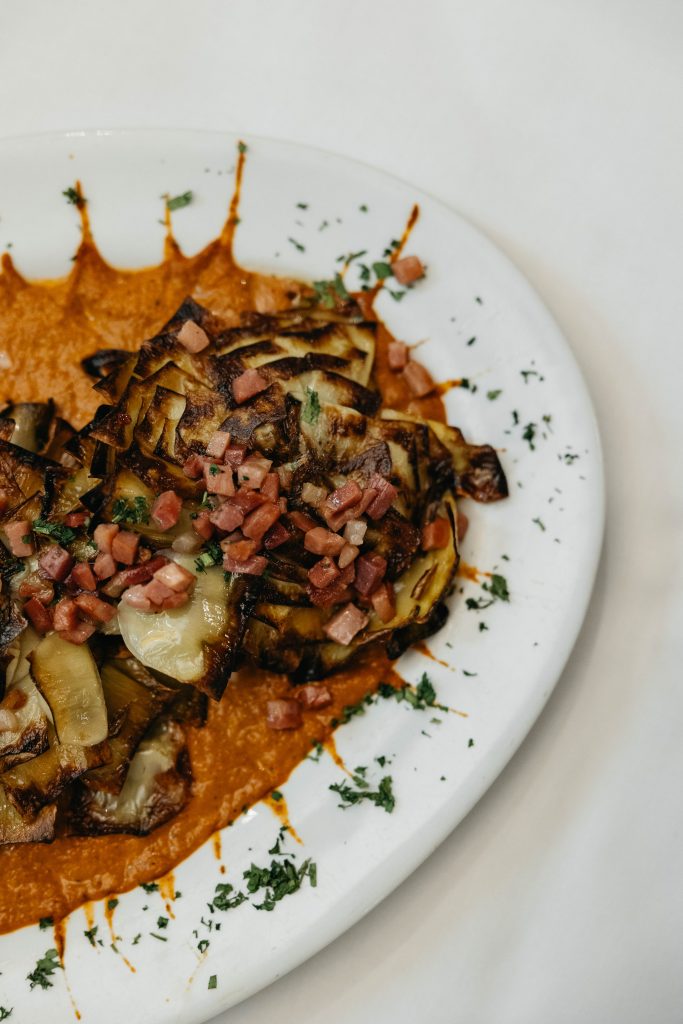 Flor de alcachofa con jamón y su salsa casera romesco