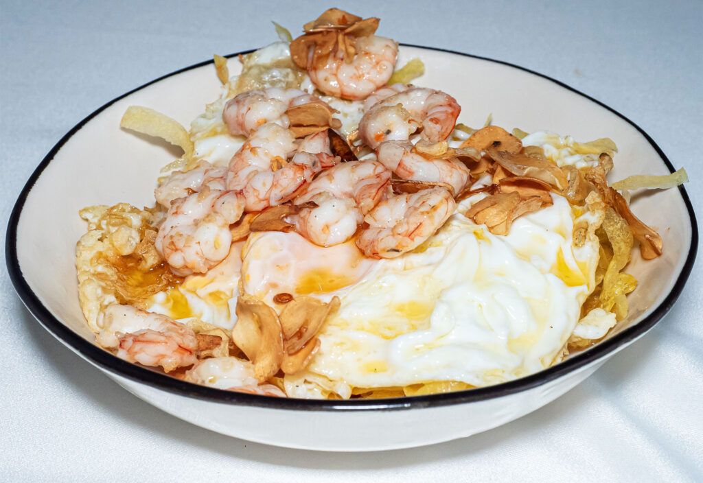 Huevos rotos con patatas chips y gambas al ajillo